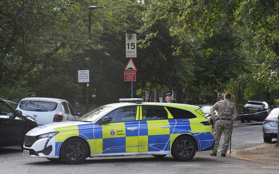 A man in military uniform stands beside a police cordon at the scene in Sally Port Gardens in Gillingham, Kent, England, Wednesday, July 24, 2024, after a soldier in uniform was stabbed on Tuesday evening, close to Brompton Barracks, the headquarters of the British Army's 1 Royal School of Military Engineering Regiment. The victim was airlifted to hospital for treatment and a 24-year-old man has been arrested on suspicion of attempted murder. (Gareth Fuller/PA via AP)