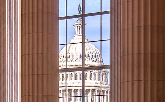 The U.S. Capitol dome seen through a window of another building.