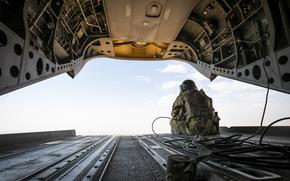 U.S. Army Spc. Jeffrey Pokryska, a CH-47 Chinook helicopter repairer assigned to Bravo Company, 3-10 General Support Aviation Battalion, keeps watch as the aircraft flies through Syria during a mission in support of Combined Joint Task Force - Operation Inherent Resolve near Al Tanf-Garrison, Syria, Nov. 1, 2024. CJTF-OIR continues to advise, assist, and enable Partner Forces in designated areas of Syria to set the conditions for long-term security and the lasting defeat of ISIS. (U.S. Army photo by Staff Sgt. Mahsima Alkamooneh)