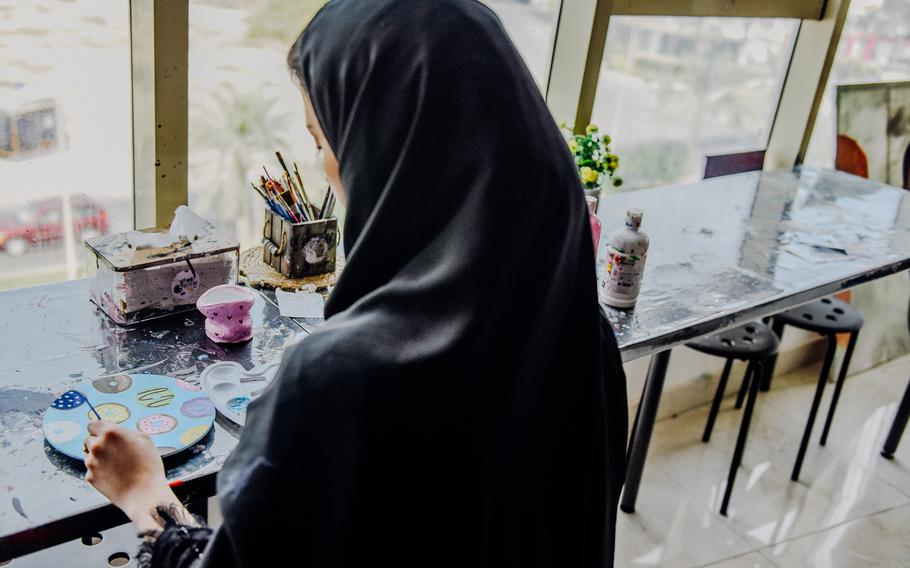 An artist puts the final touches of paint on one of the plates available for purchase at the Passion Art Cafe in Budaiya, Bahrain.