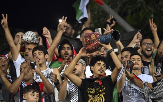 Fans pose for photos as they wait the start of a World Cup Qualifier between the Palestinian soccer team and Jordan at Cheras Stadium in Kuala Lumpur, Malaysia, Tuesday, Sept. 10, 2024. (AP Photo/Vivian Lo)