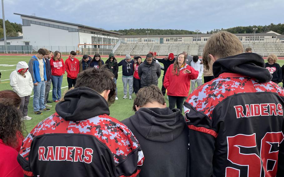 Teammates and friends participate in a prayer for injured Kaiserslautern High School football player Aiden Wall.