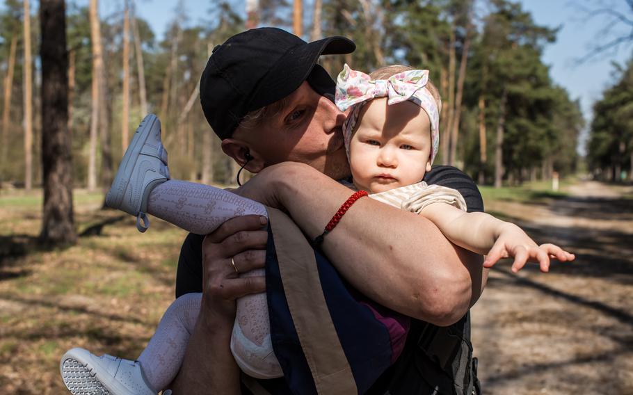 Kozachok holds Isabella during a walk in the forest.