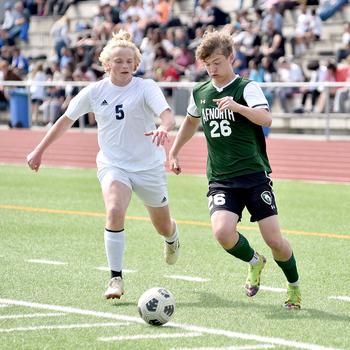 AFNORTH senior Santiago Aponte dribbles past Ansbach right back Sam Hanson during the Division III boys title match at the DODEA European championships on May 23, 2024, at Ramstein High School on Ramstein Air Base, Germany.