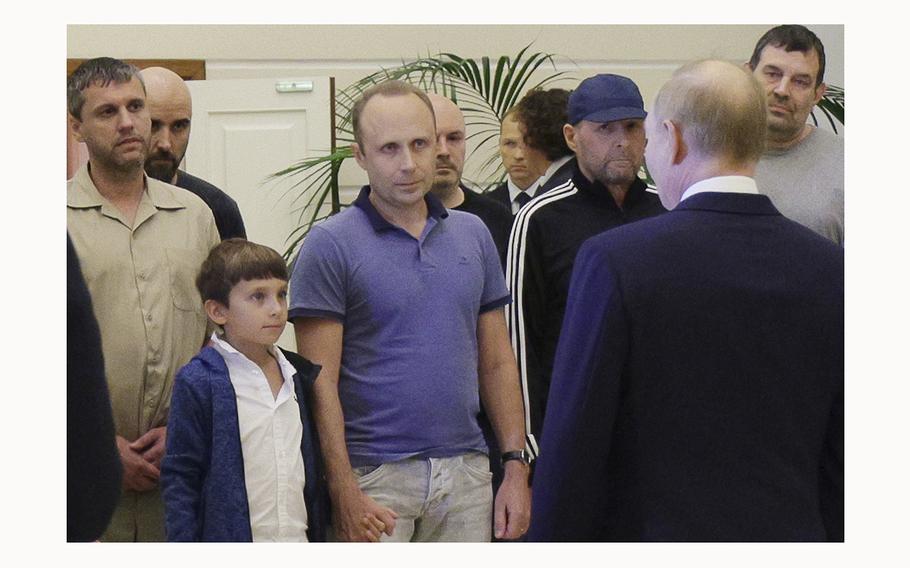 A man identified as Pablo González, a freelance journalist from Spain who had been based in Poland since 2019, second from left with shaved head, listens to Russian President Vladimir Putin, back to a camera, speaking to released Russian prisoners, part of the biggest prisoner swap between the United States and Russia in post-Soviet history, upon their arrival at the Vnukovo government airport outside Moscow, Russia, on Thursday, Aug. 1, 2024. Gonzalez had another passport and another name: Pavel Rubtsov. 