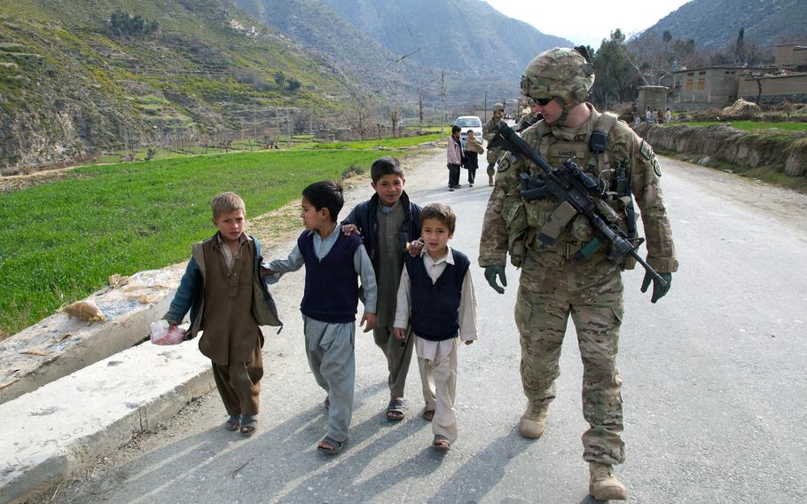 1st Lt. Michael Baker, a 25-year-old platoon leader from Bogalusa, La., talks with children 