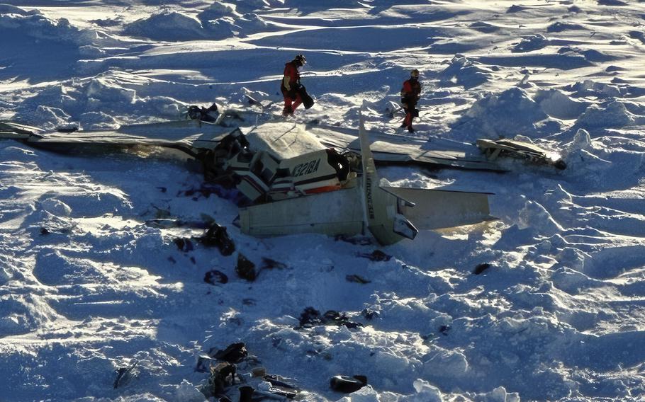 Rescuers search the wreckage of a plane crash in the snow in Alaska.