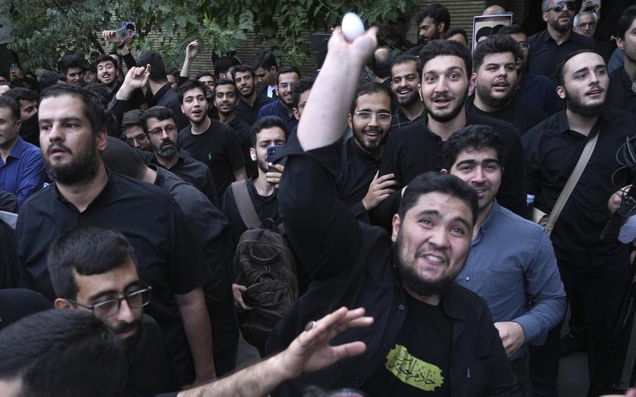 A demonstrator throws an egg at the Swedish Embassy in Iran