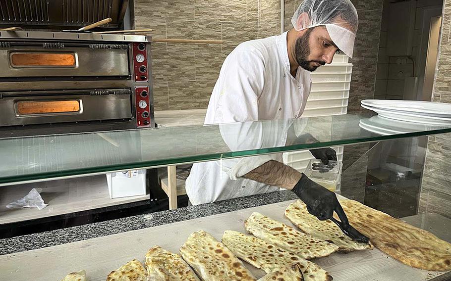 Ali Alizay, a baker at Miami Food in Kaiserslautern, Germany, brushes oil on bolani, Afghan-style flatbread stuffed with potatoes or onions.