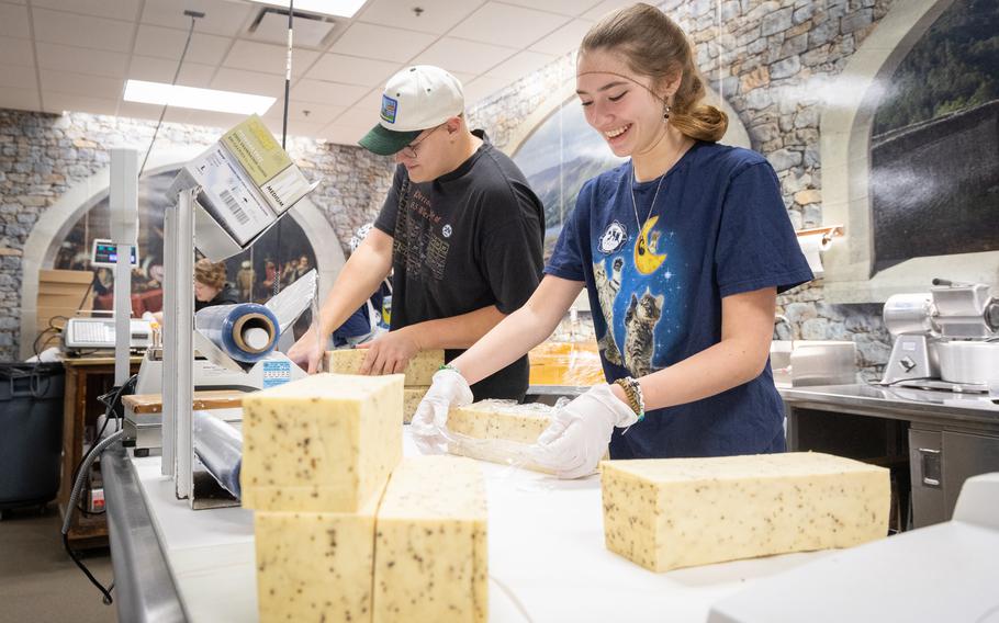 Two Mars Cheese Castle employees prepare cheeses. 