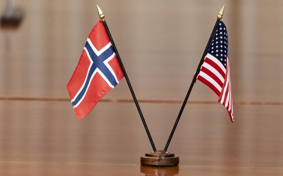 Small Norwegian and U.S. flags stand in a holder on a table.