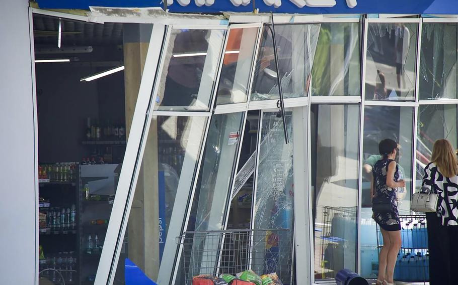 In this photo released by the Dnipro Regional Administration, people stand near shop windows damaged following Russia’s missile attack in Dnipro, Ukraine, Wednesday, July 3, 2024. 