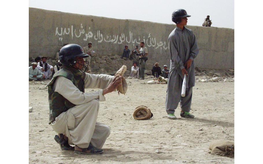 An Afghan boy takes some practice pitches before another boy steps up to home plate for his at-bat in Orgun-e, Afghanistan.