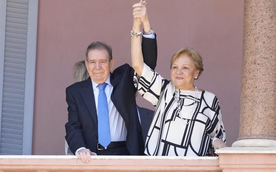 Venezuela's opposition leader Edmundo Gonzalez Urrutia and his wife Mercedes Lopez hold hands from the government house balcony in Buenos Aires, Argentina, Saturday, Jan. 4, 2025. Gonzalez, who claims he won the 2024 presidential election and is recognized by some countries as the legitimate president-elect, traveled from exile in Madrid to Argentina. (AP Photo/Natacha Pisarenko)