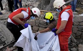 Lebanese Red Cross volunteers and Civil Defence worker remove the remains of killed people from the rubble of a destroyed building at the site of Monday's Israeli airstrike in Aito village, north Lebanon, Tuesday, Oct. 15, 2024. 