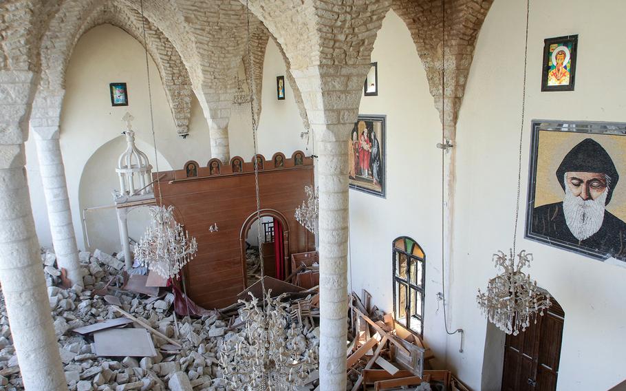 The first floor of a church in southern Lebanon is seen covered in rubble, as viewed from a higher floor in the church.