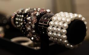 Jeweled bracelets sit on display in a case.