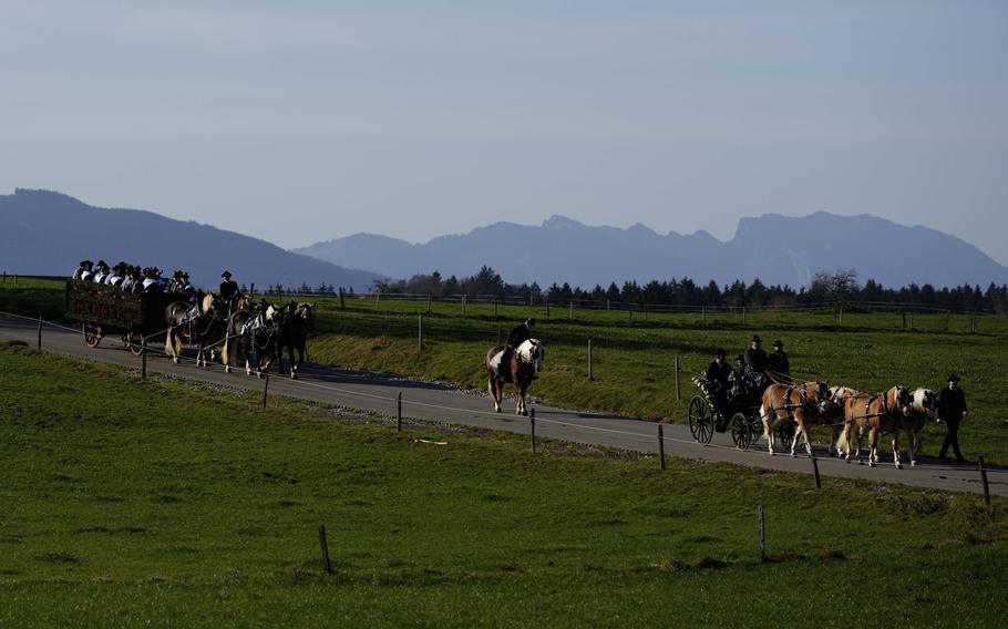 People in horse-drawn carriages and costumes take part in a pilgrimage in the German countryside.