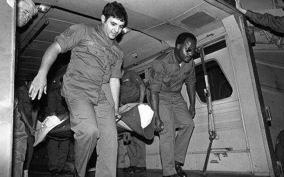 An unidentified burn victim is carried on a stretcher out of an ambulance onto a C-141 Air Force plane to be strapped in for the flight Oct. 22, 1979.