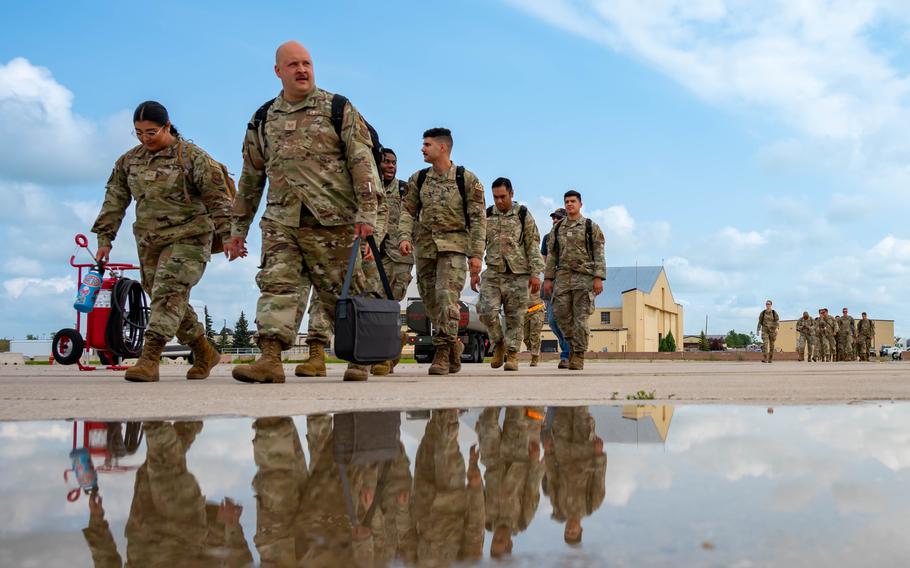 Team Minot Airmen walk toward a passenger jet in preparation for exercise Agile Warbird at Minot Air Force Base, N.D., July 13, 2024. 