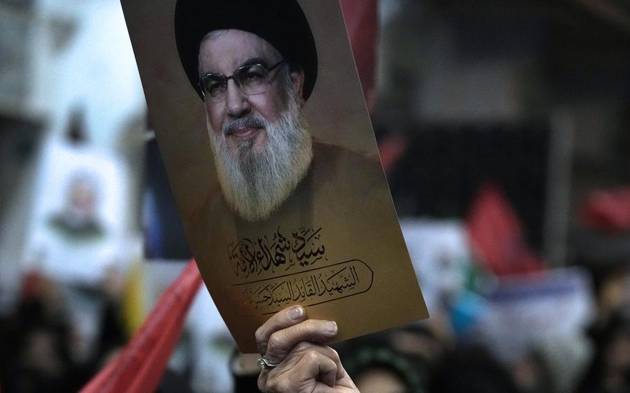 A woman holds up a poster of slain Hezbollah leader Hassan Nasrallah.