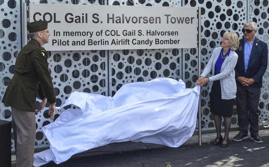 Army Col. David Mayfield and Denise Williams, daughter of “The Candy Bomber” Col. Gail Halvorsen, unveil a nameplate dedicating a new air traffic control tower in honor of Halvorsen during a ceremony June 15, 2024, on Clay Kaserne in Wiesbaden, Germany.