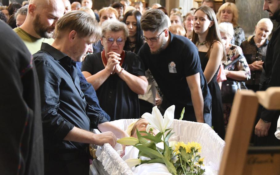 Yaroslav Bazylevych, second left, mourns at the coffins of his family during their funeral service in Lviv, Ukraine, Friday, on Sept. 6, 2024.