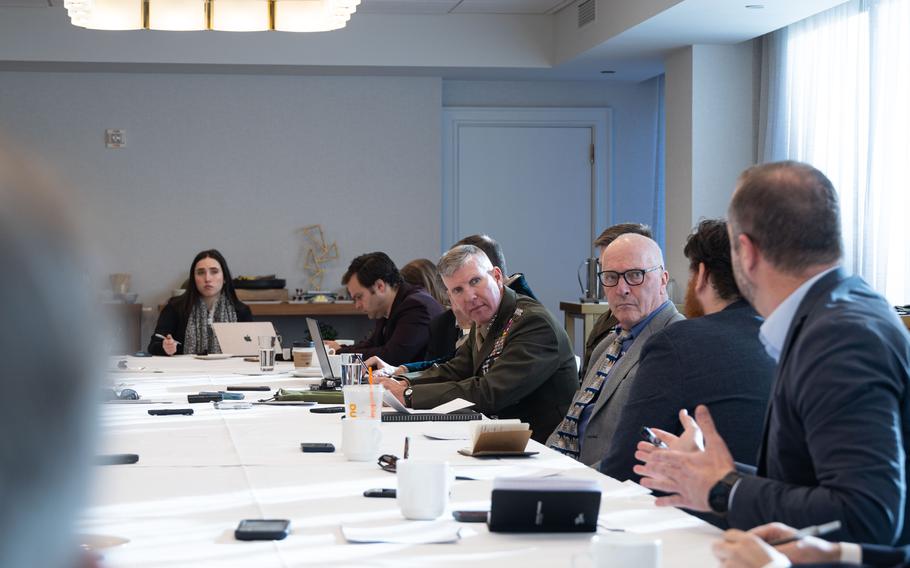 Smith sits and talks at a conference table with others. 