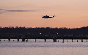 A helicopter flies over the Potomac River near Ronald Reagan Washington National Airport, Thursday, Jan. 30, 2025, in Arlington, Va. (AP Photo/Carolyn Kaster)