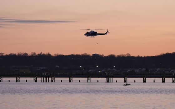 A helicopter flies over the Potomac River near Ronald Reagan Washington National Airport, Thursday, Jan. 30, 2025, in Arlington, Va. (AP Photo/Carolyn Kaster)