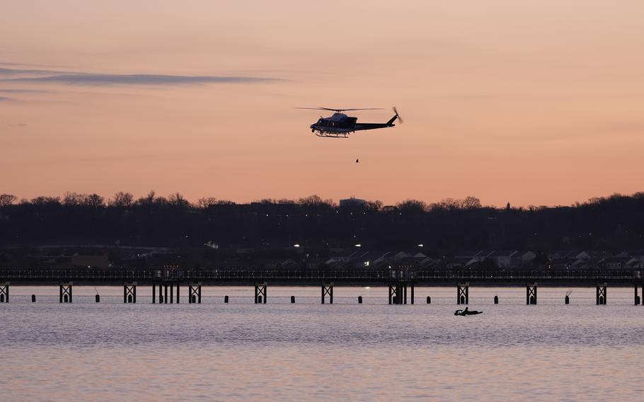 A helicopter flies over the Potomac River in Washington at sunrise.