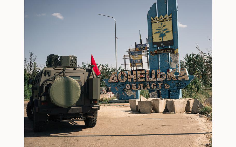 A Ukrainian armored vehicle parked by a sign marking an entrance to the Donetsk region in eastern Ukraine. 