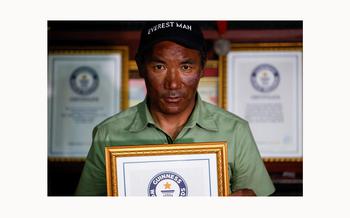 Nepali Mountaineer Kami Rita Sherpa, surrounded by his previous Guinness World Record for his climbs to the summit of Mt. Everest, holds a framed certificate at his apartment in Kathmandu, Nepal on May 28, 2023.