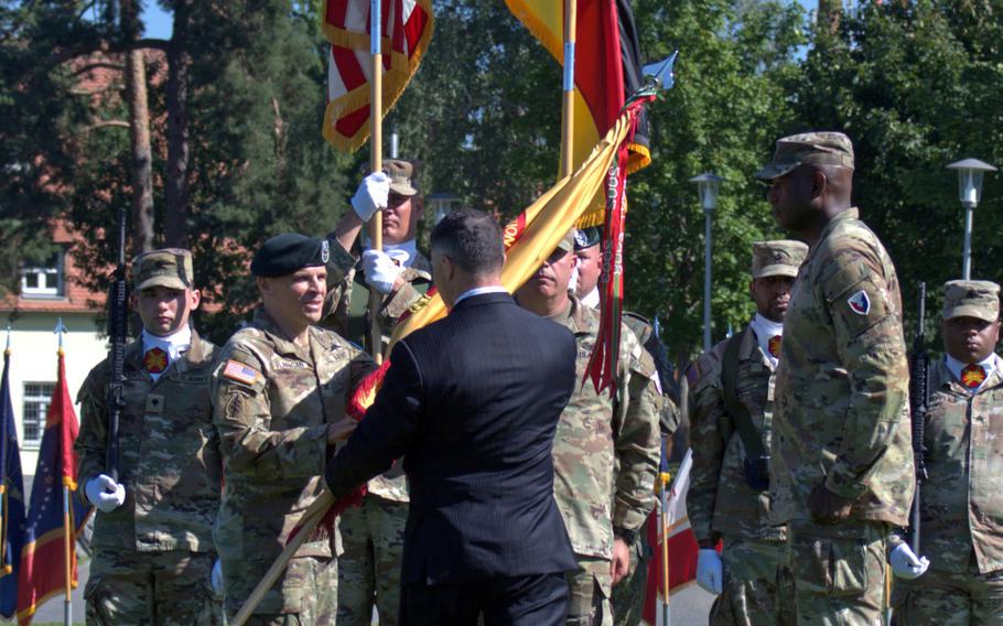 Col. Stephen Flanagan, left, accepts the U.S. Army Garrison Bavaria colors during a change of command ceremony at Tower Barracks in Grafenwoehr, Germany, on Aug. 6, 2024. 