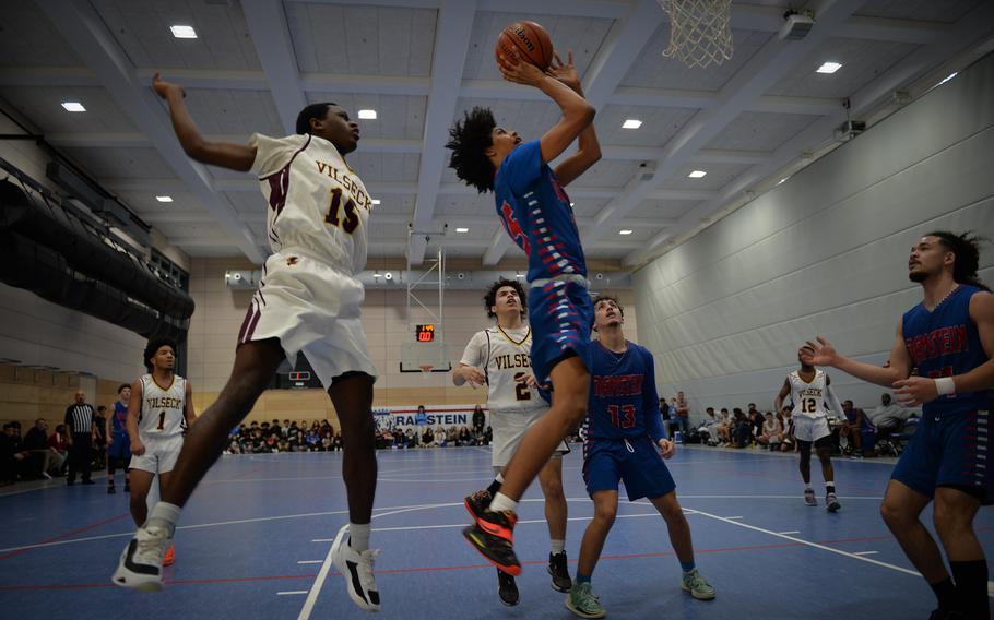 Ramstein’s Angel Jones drives to the basket past Vilseck’s Ibrahima Balde, right, and Braxton Bixler during the DODEA European Division I boys basketball championships at Ramstein Air Base in Germany on Feb. 16, 2023.