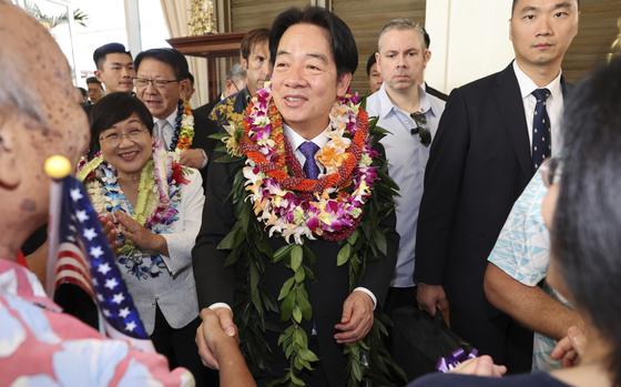 Taiwan President Lai Ching-te wears a Hawaiian lei and shakes hands with people.