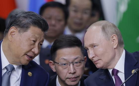 Chinese President Xi Jinping, left, and Russian President Vladimir Putin, right, speak during Outreach/BRICS Plus format session at BRICS Summit in Kazan, Russia, Thursday, Oct. 24, 2024. (Maxim Shemetov, Pool Photo via AP)