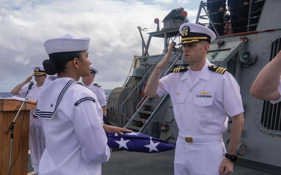 PACIFIC OCEAN (Mar. 19, 2024) The honor guard retires the colors and presents the national ensign to Cmdr. Cameron Yaste, the Commanding Officer of the Arleigh Burke-class guided-missile destroyer USS John S. McCain (DDG 56) during a burial at sea ceremony. The ship is in U.S. 7th Fleet conducting routine operations. 7th Fleet is the U.S. Navy's largest forward-deployed numbered fleet, and routinely interacts and operates with Allies and partners in preserving a free and open Indo-Pacific Region. (U.S. Navy photo by Mass Communication Specialist 3rd Class Kevin Tang)