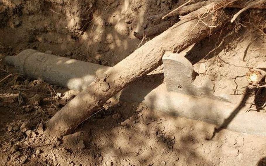 A 500-year-old bronze cannon semi-buried in the ground.