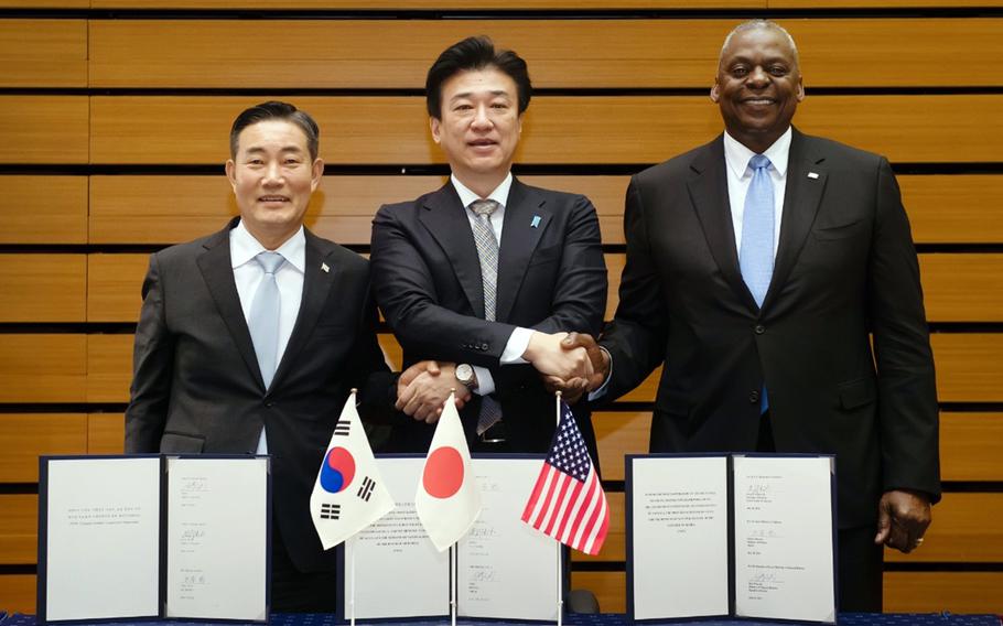 South Korean Defense Minister Shin Won-sik, left, Japanese Defense Minister Kihara Minoru, center, and Defense Secretary Lloyd Austin pose after signing a memorandum in Tokyo, Sunday, July 28, 2024.