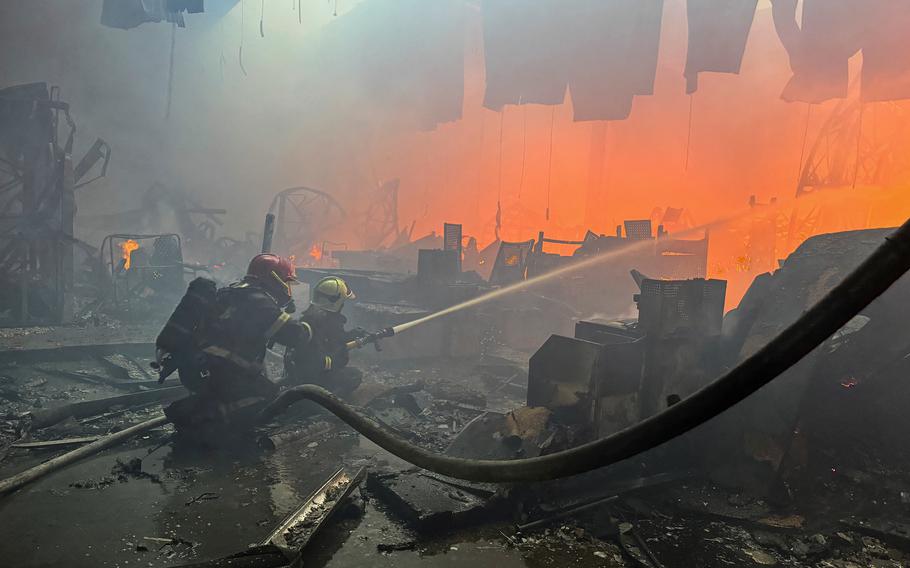 Firefighters work at a site of a household item shopping mall hit by a Russian airstrike in Kharkiv, Ukraine, May 25, 2024. 