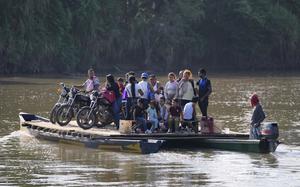 Residents cross a river to Venezuela from Colombia's Tibu, Tuesday, Jan. 21, 2025, following guerrilla attacks that killed dozens and forced thousands to flee their homes in the Catatumbo region. (AP Photo/Fernando Vergara)