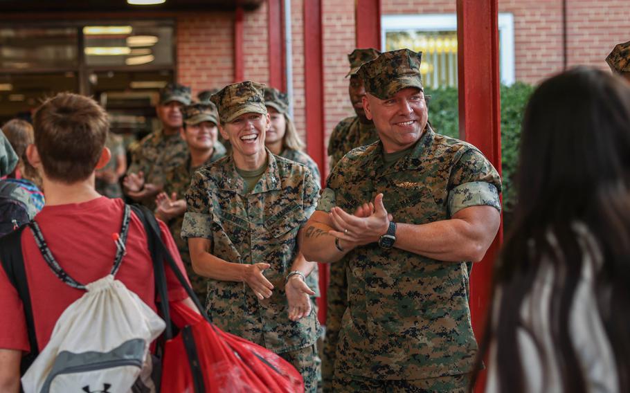 U.S. Marine Corps Sgt. Maj. Michael R. Brown, sergeant major of Marine Corps Base Quantico, right, and Col. Jenny Colegate, commanding officer of MCBQ, welcome students during a back-to-school celebration at the Quantico Middle/High School on Marine Corps Base Quantico, Va., Aug. 21, 2024. 