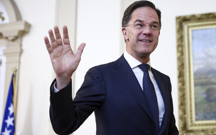 Mark Rutte smiles and waves one hand.