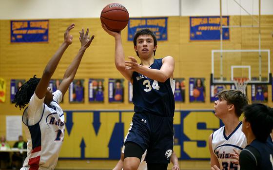 Black Forest Academy shooting guard Mateo Chamberlain goes for a floater against Aviano guard Bryson Russell during a Division II pool-play game at the 2025 DODEA European basketball championships on Feb. 12, 2025, at Wiesbaden High School in Wiesbaden, Germany.