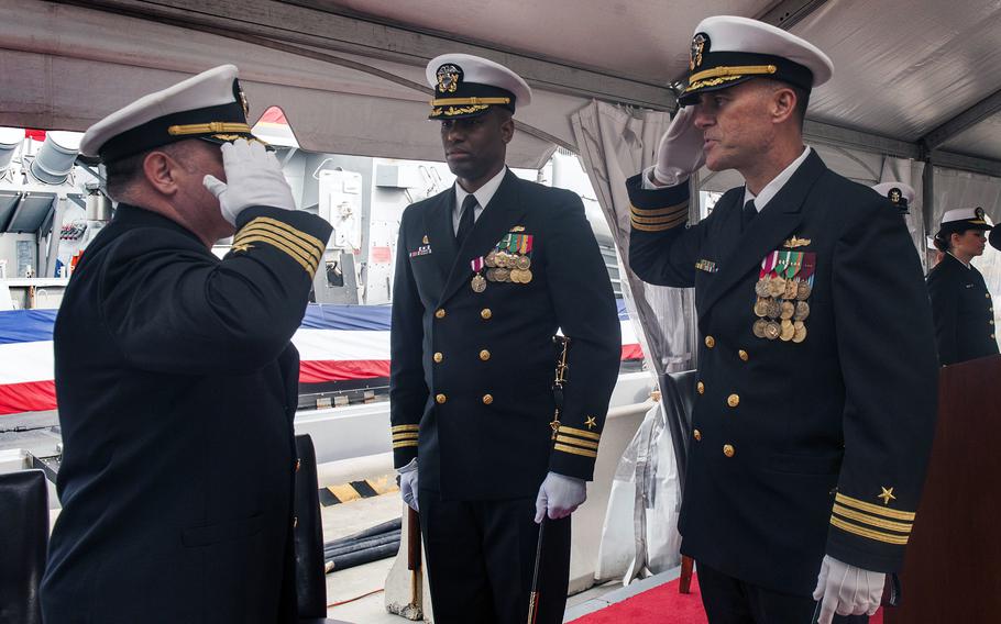 A Navy change-of-command ceremony aboard the guided-missile destroyer USS McFaul in 2014. Capt. Cary Krause salutes Cmdr. Michael Gunther as then-Cmdr. Lester Brown looks on.