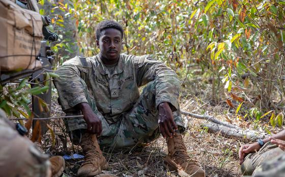 U.S. Army Pfc. Dewayne Johnson, a cavalry scout assigned to 3rd Squadron, 4th Cavalry Regiment, 3rd Infantry Brigade Combat Team, 25th Infantry Division, sits with his teammates during an exercise at Helemano Military Reservation, Hawaii, Nov. 2, 2023. 