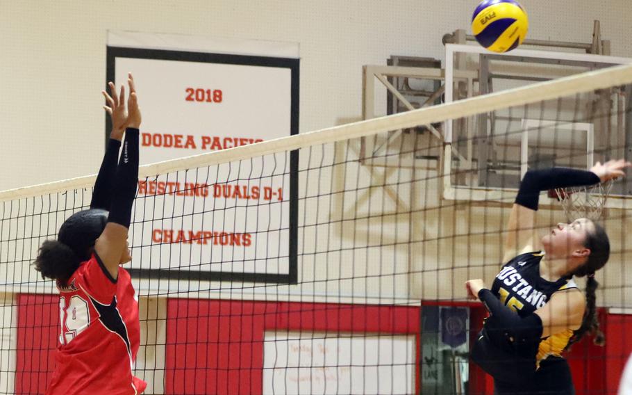 American School In Japan's Mari Ennis spikes against Nile C. Kinnick's Alyssa Staples during Tuesday's Kanto Plain volleyball match. The Mustangs won in two sets.