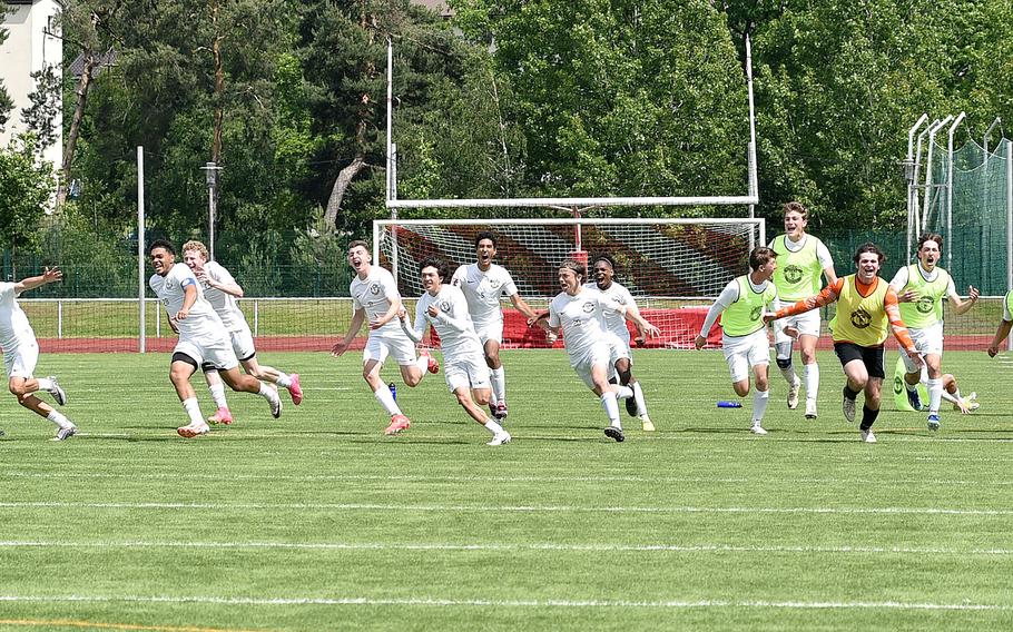 The Ramstein boys soccer team celebrates after senior Mathias Bailey scored the winning penalty against Stuttgart in a Division I semifinal of the DODEA European soccer championships May 22, 2024, at Kaiserslautern High School in Kaiserslautern, Germany.