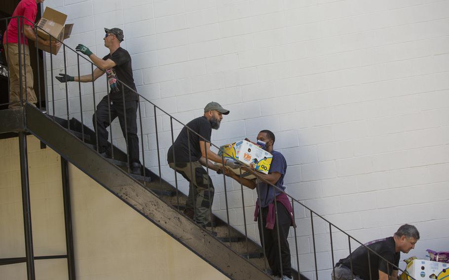 Members of American Legion Post 37 in Norfolk pass food boxes down a stairway